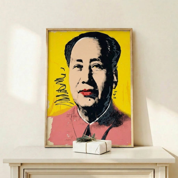 Framed pop art print showing Mao's face in saturated reds and golds with graphic simplification typical of Warhol's celebrity portraits.