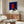 Contemporary pop art portrait in cream, electric blue, and lime green framed on a wall; celebrates 1970s avant-garde style with glamorous, ironic visual impact.