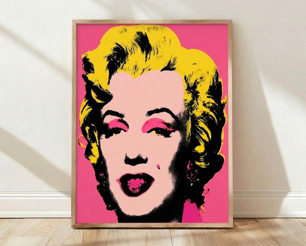Bold pop art portrait featuring a stylized face in vibrant pink, yellow, and blue tones on a contrasting background, framed and hung on a wall.