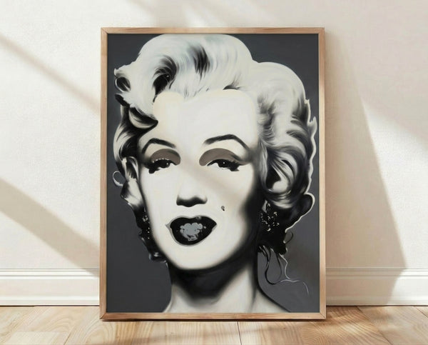Monochrome pop art portrait of Marilyn Monroe in the style of Andy Warhol, featuring bold graphic lines and high contrast black and white tones framed on a wall.