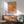 Serene abstract art print framed on wall, displaying soft coral, golden yellow, and warm earth tones in minimalist layered rectangles.