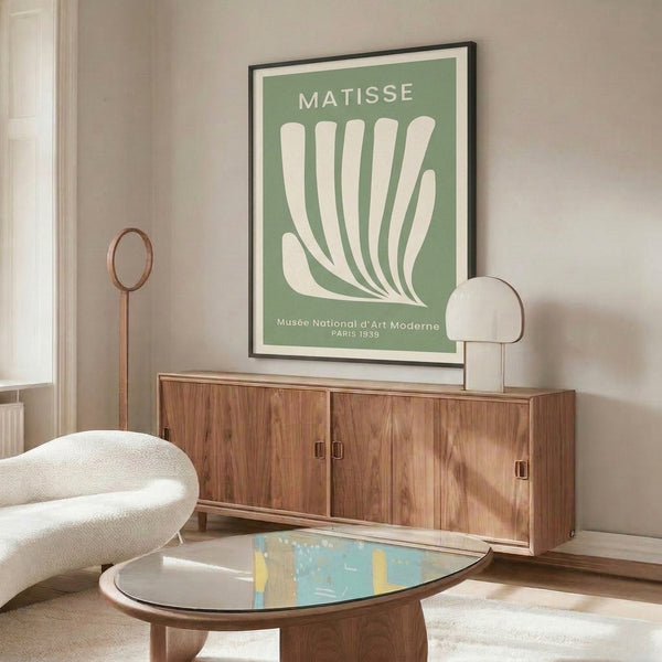 Framed mid-century modern print inspired by Matisse, depicting a delicate hand with organic foliage in soft sage green, serene Bauhaus aesthetic.