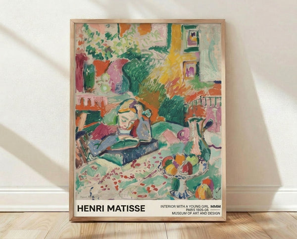 Matisse-inspired framed poster depicting a young girl in a vibrant interior with emerald green walls, featuring a chair, table with fruit and flowers, rendered in warm yellows, coral reds, and soft pinks.