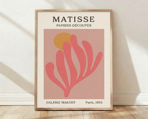 Framed abstract plant form poster in dusty rose, coral pink, and ochre gold on cream background, inspired by mid-century modern paper cut art.