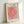 Abstract botanical cut-paper style framed poster featuring soft pink and golden ochre shapes on neutral background, capturing refined modernist elegance.