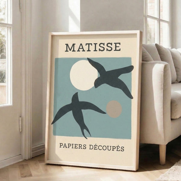 Minimalist framed poster with cut-paper bird and moon motif in soft white and charcoal, drawing inspiration from celebrated 20th-century collage techniques.