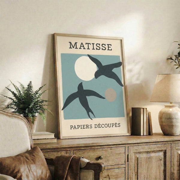 Serene wall art print combining geometric bird form and lunar shape in muted palette of blue, cream, and black with playful sophistication.