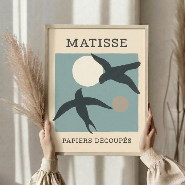 Elegant framed art print showcasing cut-out bird and crescent moon design in charcoal, cream, and subtle blue hues with refined artistic restraint.