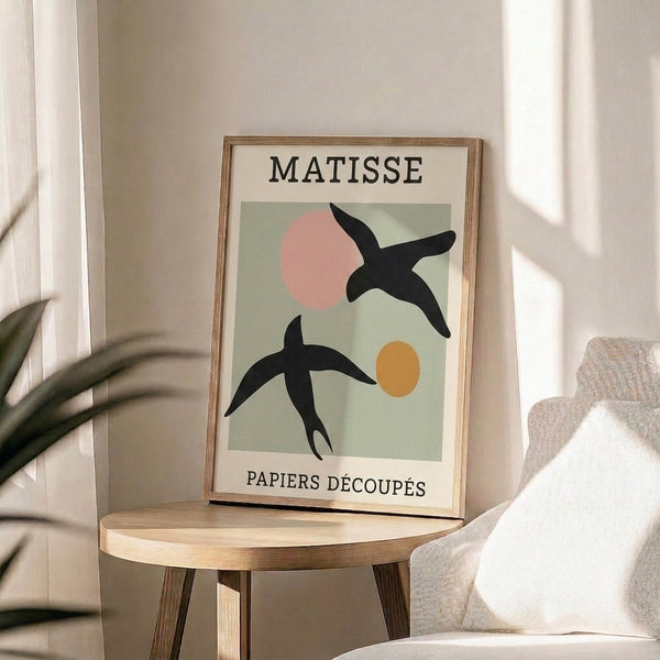Minimalist framed artwork featuring stylized birds through abstract overlapping shapes in sage green, blush pink, ochre, and cream tones with Bauhaus sensibility.