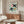 Abstract birds rendered as overlapping paper-cut forms in minimalist palette of sage green, blush, and cream with ochre accents; mid-century modern aesthetic.