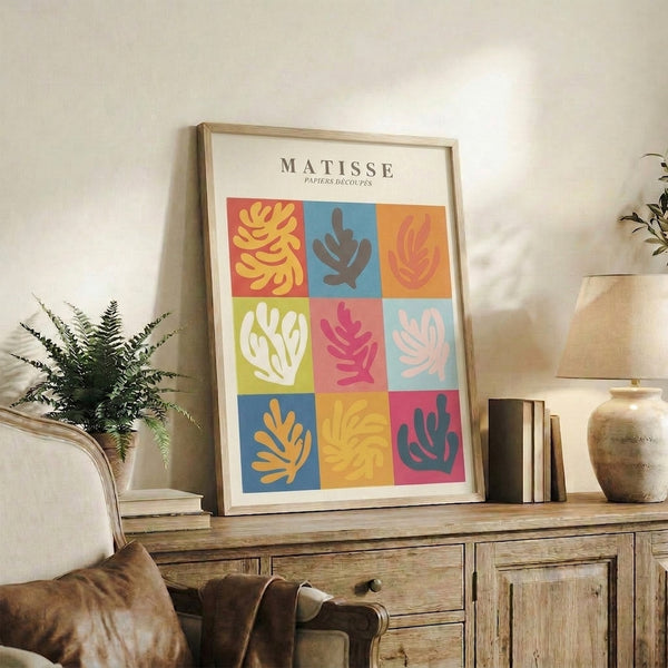 Colorful contemporary print featuring interlocking abstract plant and seaweed silhouettes in warm and cool palette of coral red, chartreuse, dusty rose, and sky blue arranged in geometric sections.
