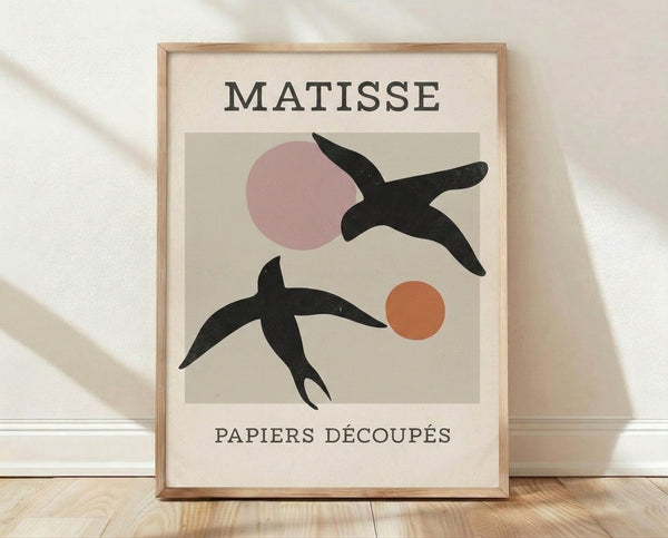 Matisse-inspired modern bird art print featuring minimalist cut-out shapes in cream, black, dusty rose, and terracotta on a framed poster.