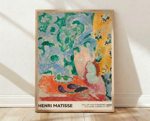 Matisse-inspired still life poster featuring vibrant aubergines, pitcher, and plate arranged on a table with emerald green foliage and soft blue tones, framed on wall.