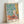 Joyful still life artwork with eggplants, tableware, and botanical elements rendered in bold Matisse style with rich emerald and golden hues.