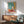 Vibrant poster art displaying Matisse-style vegetables, pitcher, and window view with joyful interplay of pale pink, emerald, and coral tones.