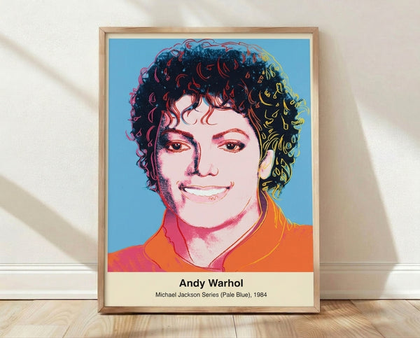 Pop art portrait of Michael Jackson in pale blue and black with pink accents, framed in modern Warhol style on a wall.