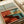 Retro diner poster art in warm earth tones—red vinyl booth, turquoise details, cream walls—with a peaceful desert view framed by the window, evoking classic American comfort and nostalgia.