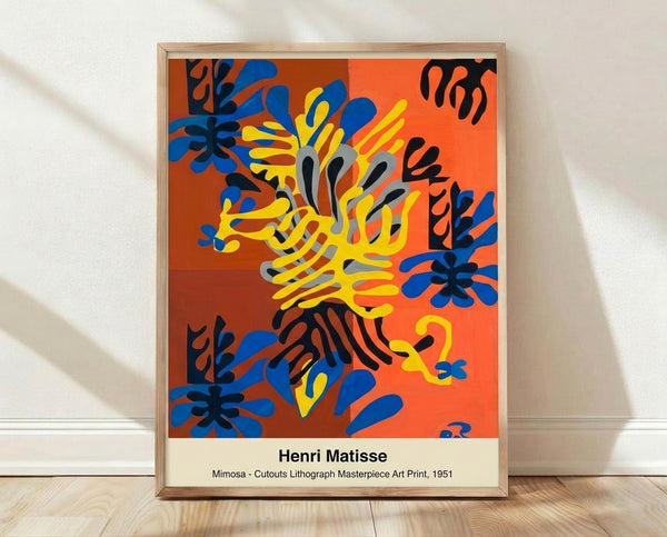 Framed abstract poster of vibrant mimosa flowers and foliage in deep red, bright orange, yellow, and blue cutout shapes on a black background, inspired by Matisse's 1951 paper cutout style.