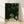 Framed minimalist botanical print featuring dark green leaves on a cream background, creating a serene Japandi-inspired wall art piece.