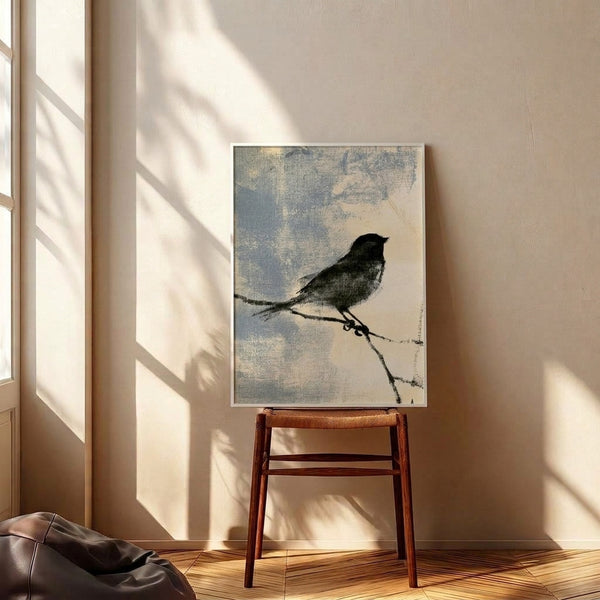 Black and cream line drawing of a single sparrow resting on a branch, displayed as a framed art print with pale blue undertones, embodying zen minimalism and wabi sabi aesthetics.