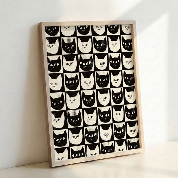 Contemporary wall art print with a geometric checkerboard grid of whimsical cat faces in black, cream, and white tones with retro graphic appeal.