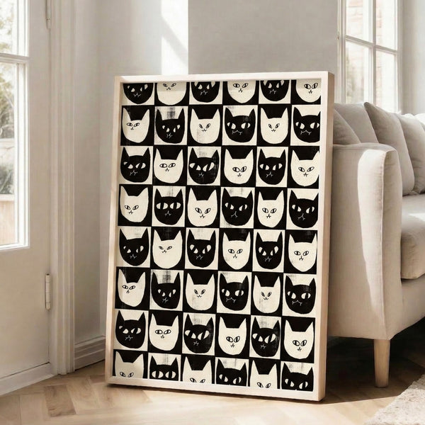 Minimalist framed poster featuring graphic cat face illustrations in black and white arranged in a checkerboard grid with a modern, whimsical aesthetic.