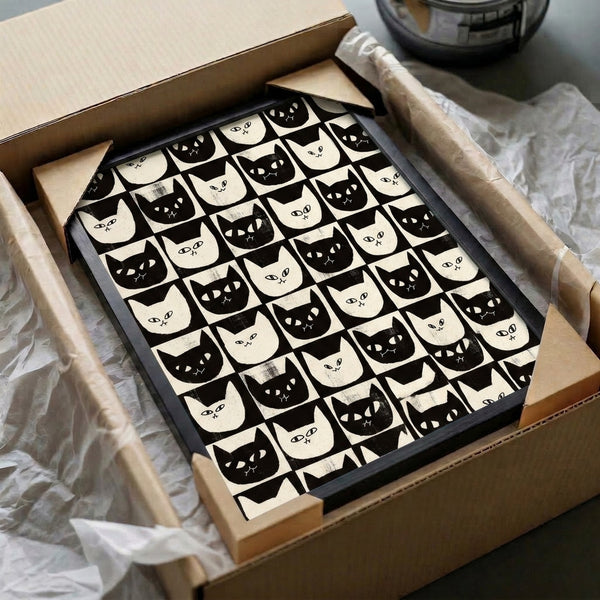 Wall art print with a graphic checkerboard layout of minimalist black cat faces on a white and cream background, evoking retro whimsy and modern style.