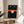 Black cat face poster art with minimalist design, glowing yellow eyes, and red mouth accent on neutral background.