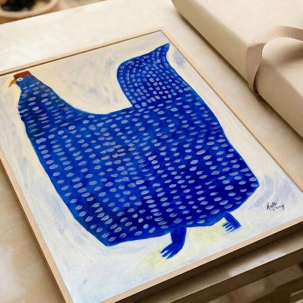 Framed minimalist hen artwork in cobalt blue, pale yellow, and cream featuring clean lines and speckled patterns with a contemporary, serene mood.