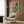 Playful abstract botanical print in cream, pink, teal, and black depicting a tropical desert garden with stylized cacti and wildlife in contemporary modern art style, displayed framed on wall.