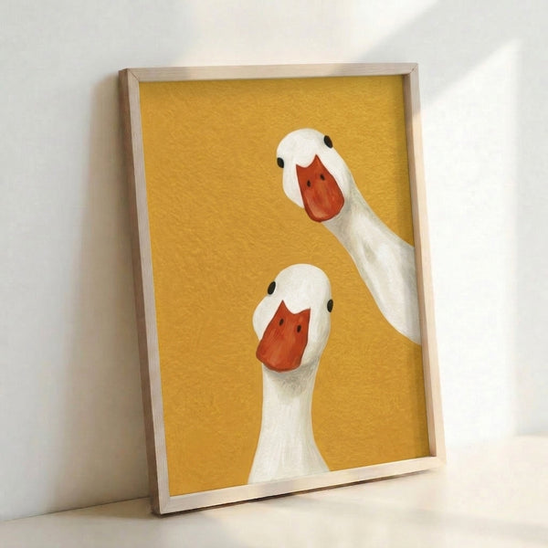 Framed print of two silly geese rendered in modern minimalist style with warm golden yellows and bold black linework, whimsical home decor.