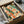 Contemporary minimalist poster featuring a geometric grid layout in rust, teal, orange, and cream tones, abstractly representing the structured energy of a crowded marketplace or reading space.