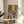 Minimalist botanical poster showcasing a bright plant-filled interior shelf with colorful blooms and greenery in warm tones creating a domestic, life-affirming artwork.