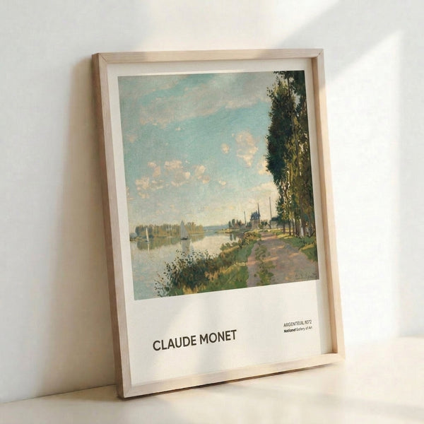 Framed impressionist art print depicting a peaceful riverside with boats, trees in muted greens, and a gentle blue sky creating a serene atmosphere.