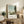 Luminous impressionist river landscape with sailboats, cream and pale blue tones, verdant trees, and atmospheric sky in a serene wall art composition.