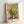 Vintage-inspired sunflower arrangement in warm rust and yellow tones with soft blue accents, rendered in loose Impressionist brushwork on a neutral ground.