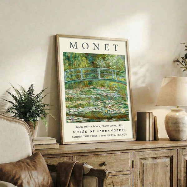 Tranquil garden scene featuring a wooden bridge over still water with floating water lilies and weeping willow branches, painted in pale blues and creamy greens in impressionist style.
