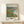 Light-filled Impressionist composition of a French village landscape with gentle hillsides, waterfront setting, and harmonious palette of cream, sage, and pale blue hues.