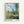 Claude Monet's View of Vetheuil framed poster featuring a bucolic countryside scene with tall poplars, wildflower meadow, and distant village nestled beneath a cream and blue sky.