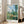 Monet-style landscape wall art showing a tranquil rural vista of Vetheuil with graceful trees, blooming poppies, and architectural silhouettes in luminous impressionist colors.