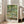 Serene garden wall art print in impressionist style showing an ornamental bridge over a pond with water lilies and drooping willow, painted in muted blues and greens.