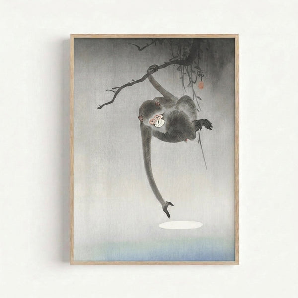Framed ukiyo-e style artwork showing a serene monkey suspended on a tree limb, featuring delicate linework and a muted palette of gray, white, and subtle red accents.