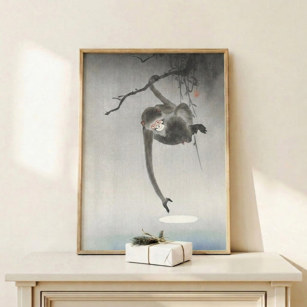 Zen-inspired framed print featuring a hanging monkey amid sparse foliage, rendered in pale blues and grays with the quiet elegance of classic Japanese printmaking.