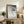 Ukiyo-e animal print mounted as wall art, depicting a monkey suspended from a branch in soft blacks and pale tones, evoking quiet contemplation and natural grace.