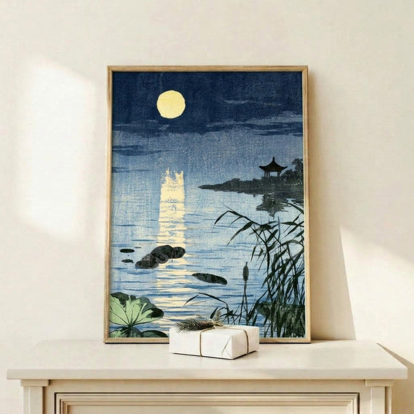 Contemplative Japandi art print showing a traditional pagoda by a moonlit lake with delicate reeds and rocks, soft yellow moon glowing against deep blue water.