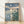 Serene Japanese woodblock-style poster featuring a moonlit lotus pond with a traditional pagoda silhouetted against a pale cream sky, rendered in slate blue and teal tones with soft gold accents and minimalist bamboo elements.