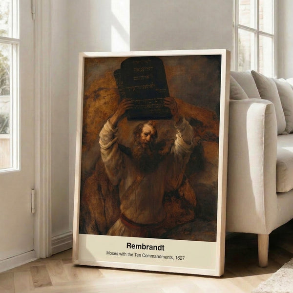 Framed Baroque painting of Moses with the Ten Commandments tablets, bathed in spiritual golden light with rich texture and shadow creating a reverent mood.