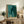 Framed poster artwork depicting a woolly mammoth and baby elephant in layered silhouettes of charcoal, gold, and sage green, evoking a quiet, nurturing moment in minimalist modern aesthetic.