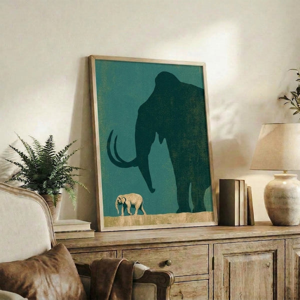 Framed poster artwork depicting a woolly mammoth and baby elephant in layered silhouettes of charcoal, gold, and sage green, evoking a quiet, nurturing moment in minimalist modern aesthetic.