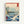 Framed Japandi art print depicting a contemplative seascape with rocky shores, towering peaks, and a solitary vessel on deep blue waves in muted earth tones.